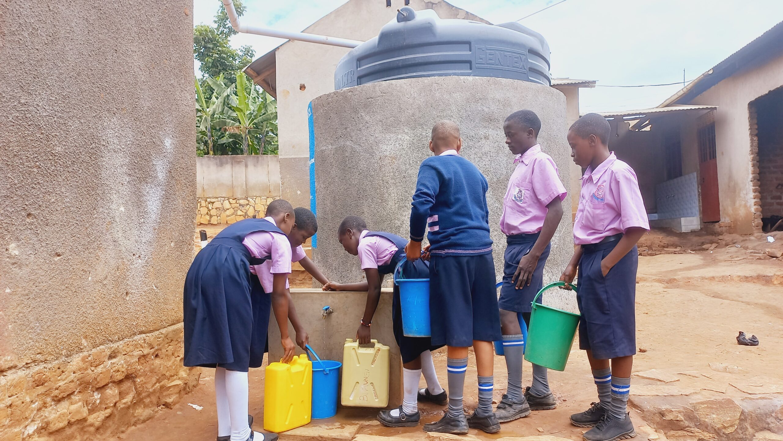 Students using water from the completed water tank at St Anne Primary school